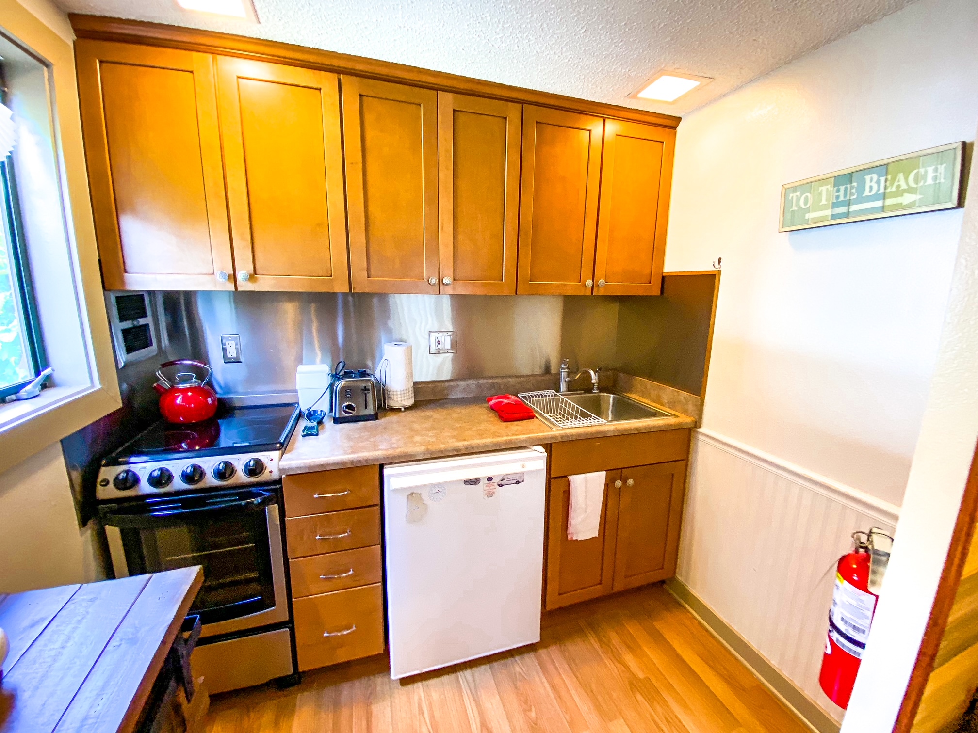 motorhome interior, kitchen, wood cabinets, microwave oven, 3-burner range,  window, mini blind, sink, tile backsplash; dinette seat, view into bedroom  Stock Photo - Alamy